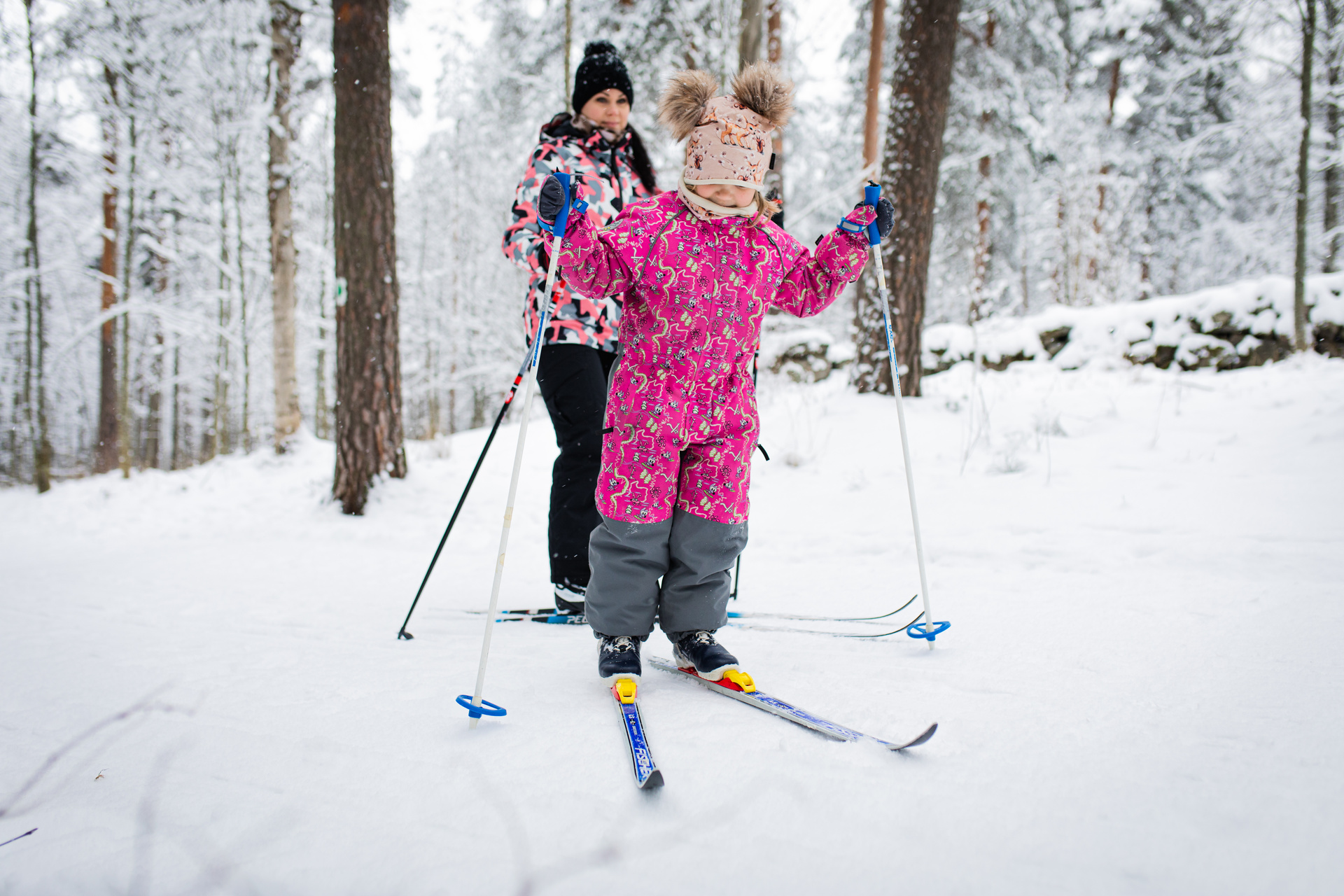 Lapsi hiihtämässä talvisessa metsässä.