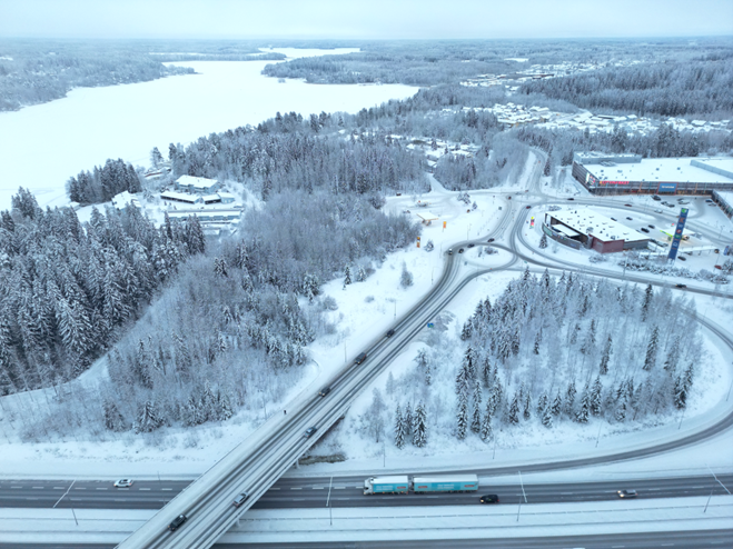 Talvinen ilmakuva Kariston alueesta. Etualalla moottoritie, taustalla siintää Kymijärvi.